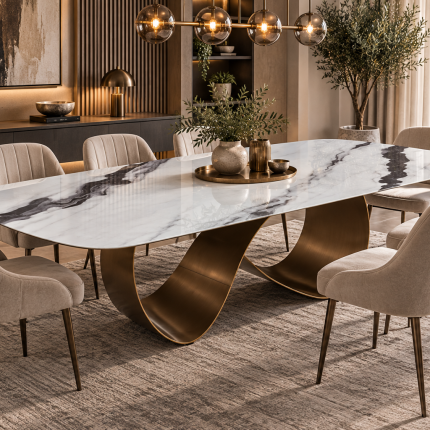 Large white marble effect dining table with grey veining, bronze sculptural pedestal base and cream upholstered chairs