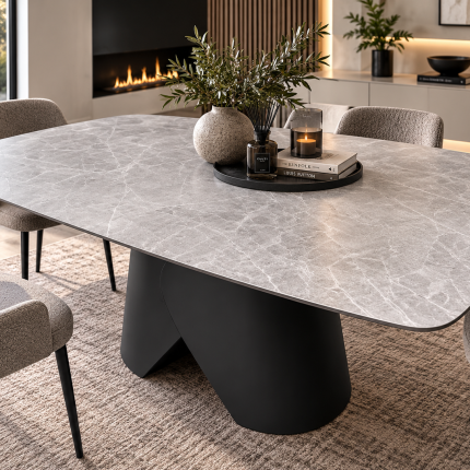 Large light grey marble effect ceramic dining table with rounded corners and black sculptural pedestal base