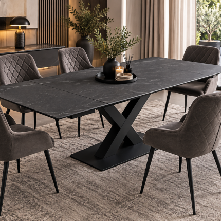 Charcoal grey extending dining table with subtle marble effect, black X-frame pedestal base and eight grey upholstered dining chairs