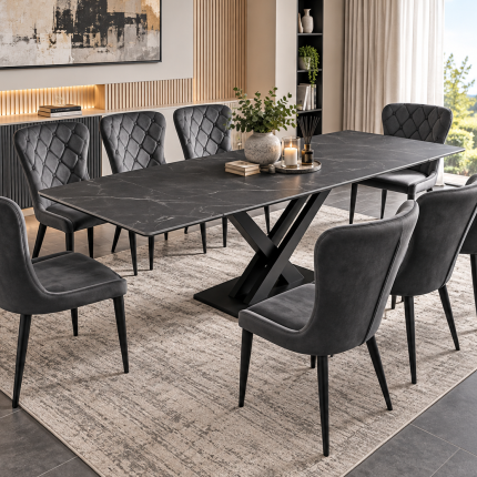 Charcoal grey extending dining table with black X-frame pedestal base and eight dark grey upholstered chairs