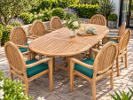 8 seater teak oval extending garden dining table with eight high-back armchairs and green cushions